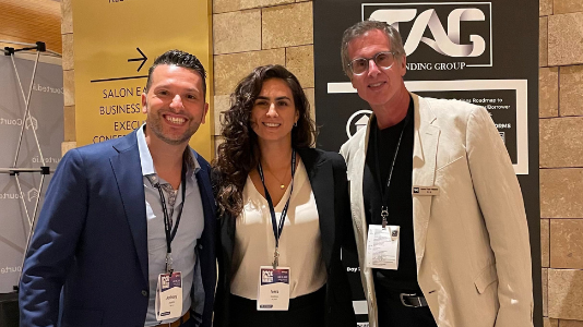 Anthony Angelillo with partners in front of the Tag Lending Group banner