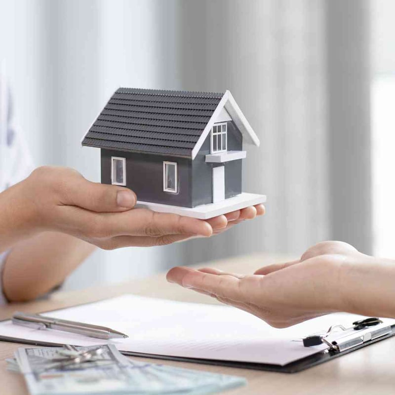 Hands presenting a model home, representing USDA loan benefits
