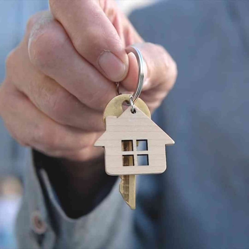 Hand holding house keys, representing USDA property requirements